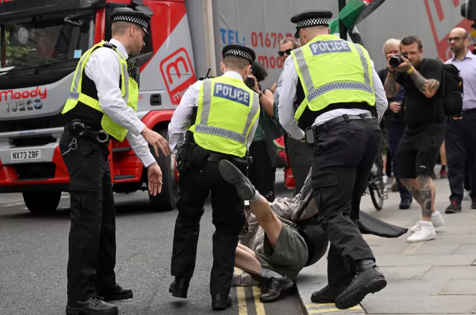 Policiais detêm um manifestante enquanto manifestantes pró-palestinos se reúnem para protestar contra os planos da Secretária do Interior britânica, Yvette Cooper, de proibir o grupo "Ação Palestina" nas próximas semanas, em Londres, Grã-Bretanha, 23 de junho de 2025