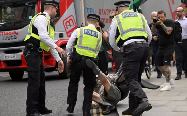 Policiais detêm um manifestante enquanto manifestantes pró-palestinos se reúnem para protestar contra os planos da Secretária do Interior britânica, Yvette Cooper, de proibir o grupo "Ação Palestina" nas próximas semanas, em Londres, Grã-Bretanha, 23 de junho de 2025