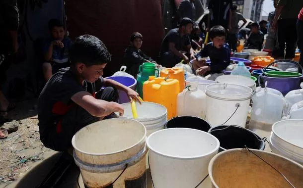 Crianças palestinas enchem recipientes de água em acampamento na Cidade de Gaza - 20/05/2025
