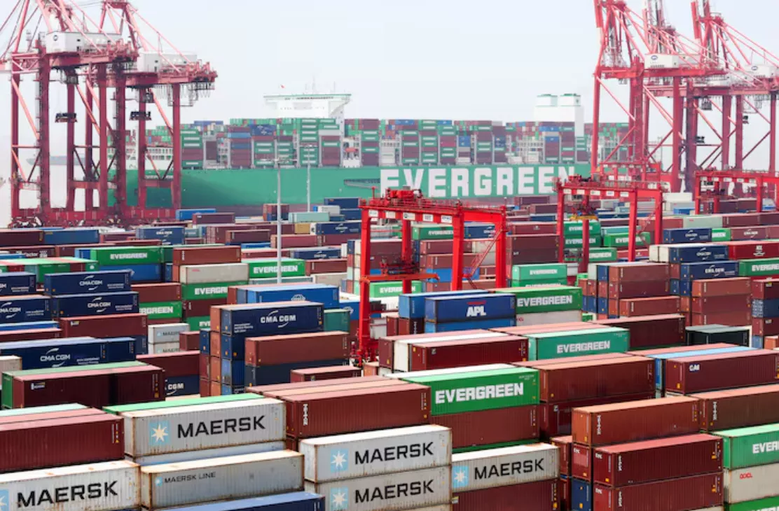 Guindastes de pórtico perto de contêineres de transporte enquanto um navio porta-contêineres da Evergreen Marine Corp, o Ever Ace, está atracado no Porto de Yangshan, nos arredores de Xangai, China, em 17 de junho de 2025