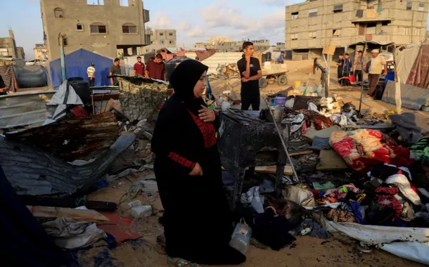 Palestinos inspecionam os danos no local de um ataque aéreo israelense durante a noite contra uma tenda que abrigava deslocados, em Khan Younis, no sul da Faixa de Gaza
