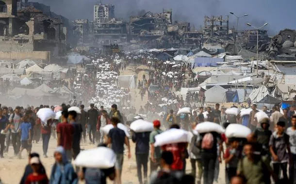 Palestinos transportam suprimentos humanitários em Beit Lahia, no norte da Faixa de Gaza - 20/07/2025
