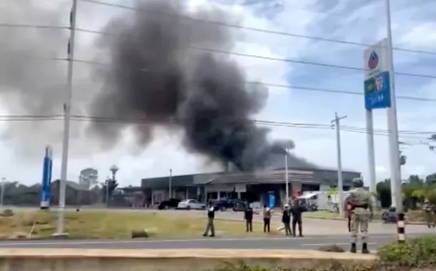 Bombeiros trabalham para extinguir incêndio em uma loja de conveniência em um posto de gasolina, em meio aos confrontos entre Tailândia e Camboja, no distrito de Kantharalak, província de Sisaket, Tailândia, em 24 de julho de 2025, nesta captura de tela obtida de um vídeo distribuído