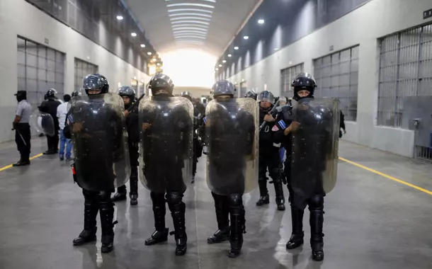 Policiais fazem guarda durante uma visita guiada para a imprensa no Centro de Confinamento do Terrorismo (CECOT), em Tecoluca, El Salvador, em 4 de abril de 2025