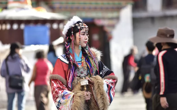 Jovem usa trajes tipicamente tibetanos