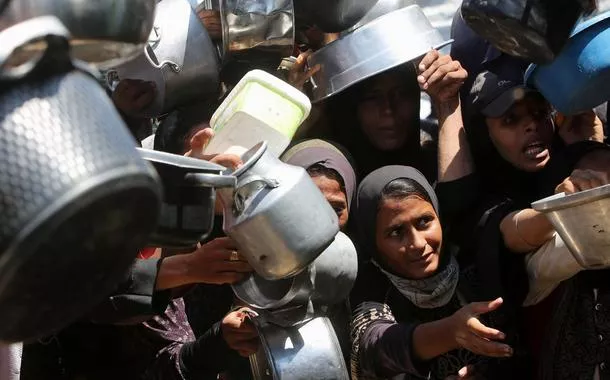 Palestinos desesperados aguardam para receber comida em Khan Younis, na Faixa de Gaza, em meio aos ataques de Israel - 04/08/2025 