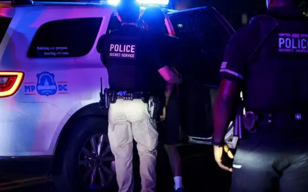 A polícia detém uma pessoa no bairro de Brightwood após o anúncio do presidente dos EUA, Donald Trump, da tomada federal do Departamento de Polícia Metropolitana sob o Home Rule Act e o envio da Guarda Nacional para auxiliar na prevenção de crimes na capital do país, em Washington, DC, EUA, em 14 de agosto de 2025