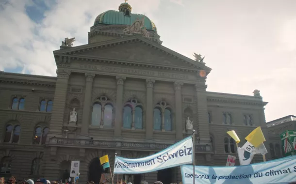 Cena do filme TROP CHAUD, mostrando uma manifestação das Anciãs pelo Clima em frente à Casa de Governo em Berna, Suíça.
Foto – MattoGrosso Films/Divulgação