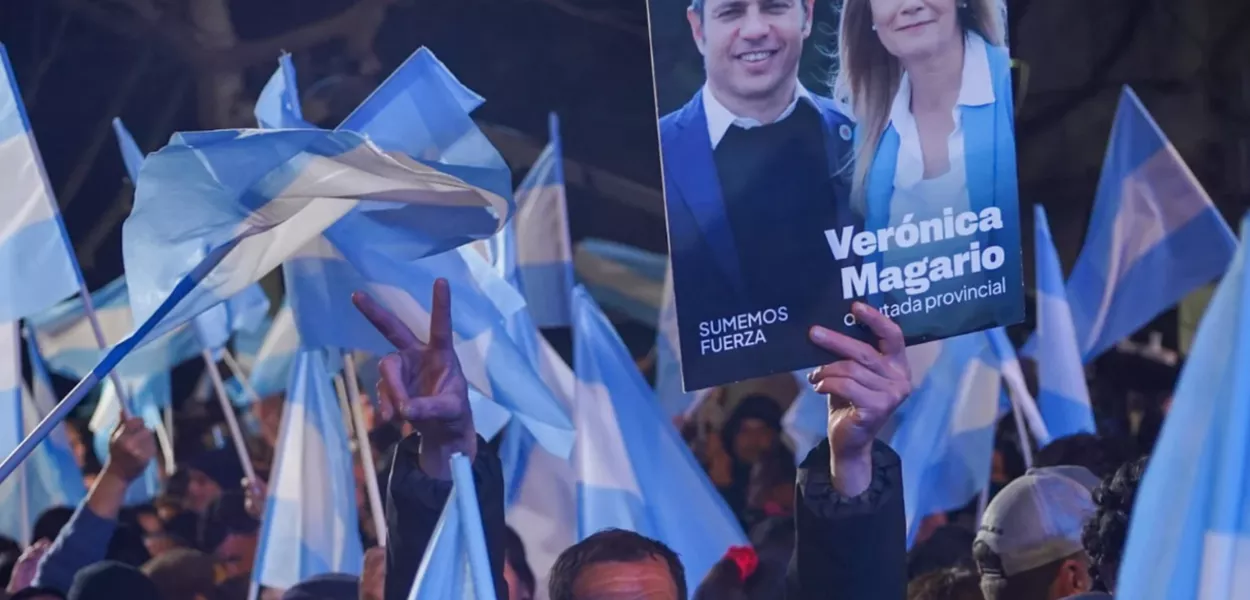 Apoiadores do Fuerza Patria celebram a vitória da coalizão com bandeiras argentinas e cartazes de Axel Kiciloff e Verônica Magario