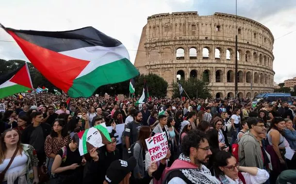 Pessoas seguram bandeiras da Palestina em frente ao Coliseu, em Roma, durante uma manifestação em apoio aos palestinos em Gaza