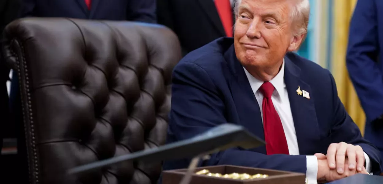O presidente dos EUA, Donald Trump, senta-se no Salão Oval para assinar uma ordem executiva sobre IA e pesquisa sobre câncer pediátrico, na Casa Branca, Washington, DC, EUA, 30 de setembro de 2025.