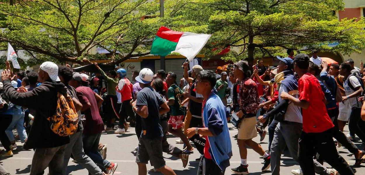 Manifestantes seguram bandeira de Madagascar durante protesto em Antananarivo contra constantes desabastecimentos de água e energia elétrica
13/10/2025 