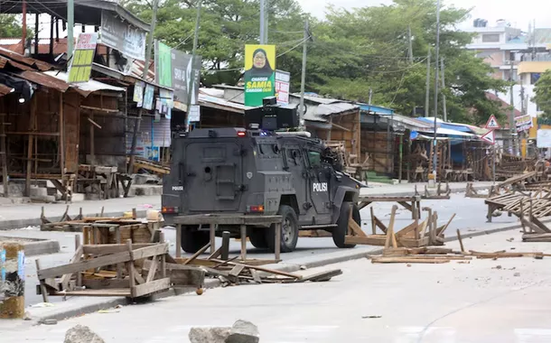 Veículo da polícia tanzaniana trafega por uma estrada bloqueada por manifestantes durante os violentos protestos que marcaram as eleições