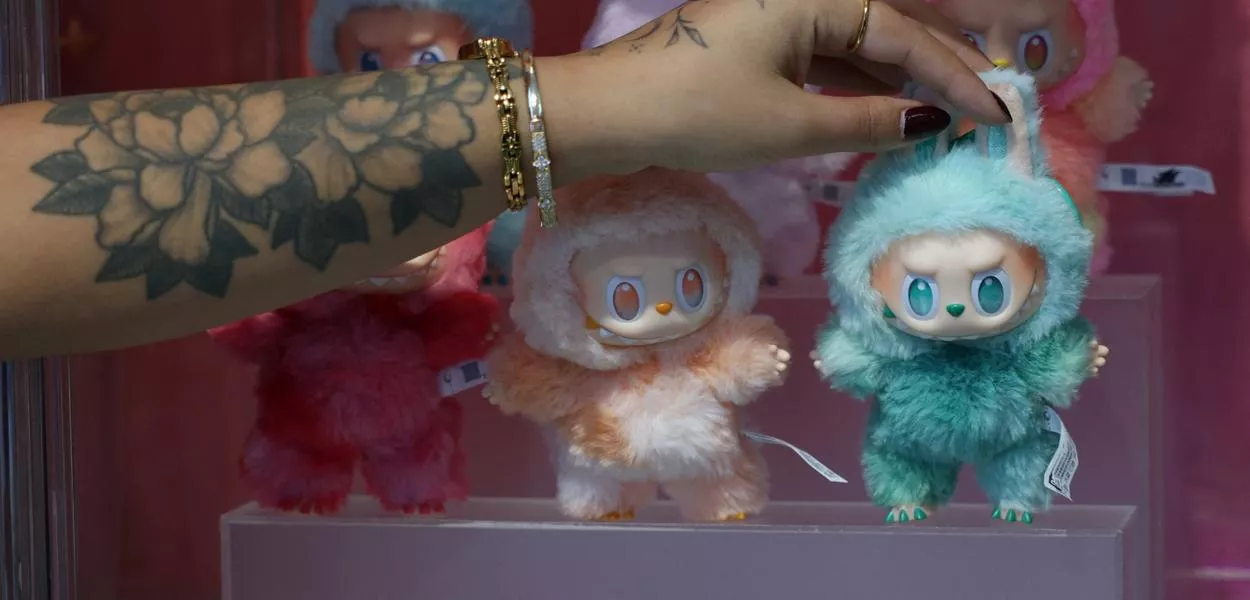 Influenciadora segura boneco Labubu, da PopMart, em vitrine em Londres, Reino Unido