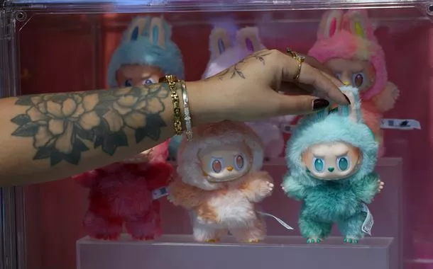 Una influencer sostiene una muñeca Labubu, de PopMart, en el escaparate de una tienda en Londres, Reino Unido.