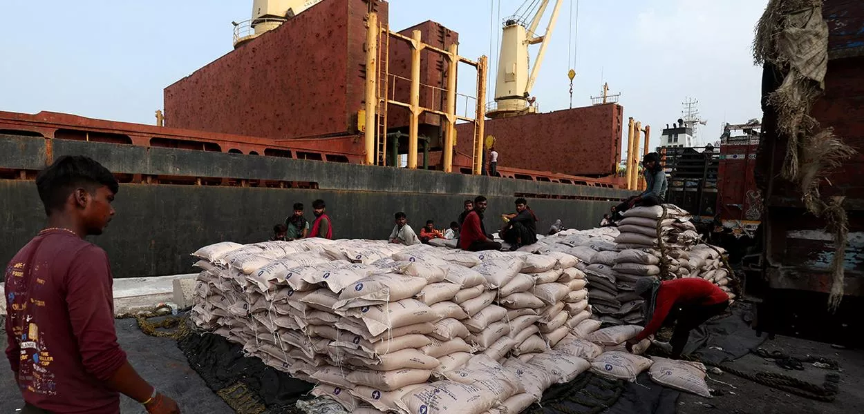 Um trabalhador organiza sacos de açúcar em uma rede para carregá-los em um navio de carga no Porto de Deendayal, em Kandla, no estado de Gujarat, oeste da Índia