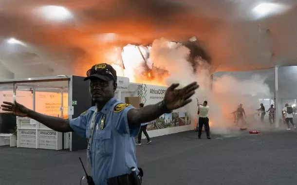 Segurança gesticula enquanto pessoas usam extintores de incêndio em fogo no Pavilhão dos Países da Zona Azul na COP30 em Belém-PA -
20 de novembro de 2025