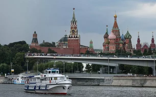 Embarcação navega pelo rio Moscou com a Torre Spasskaya do Kremlin e a Catedral de São Basílio ao fundo - 14 de julho de 2025