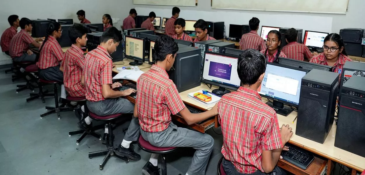 Ahmedabad, Índia - 15 de maio de 2025 - Alunos do Adani Vidya Mandir Ahmedabad (AVMA) estudam em um laboratório de informática. A AVMA, voltada a alunos em situação financeira vulnerável, registrou uma taxa de aprovação de 100% nos rankings