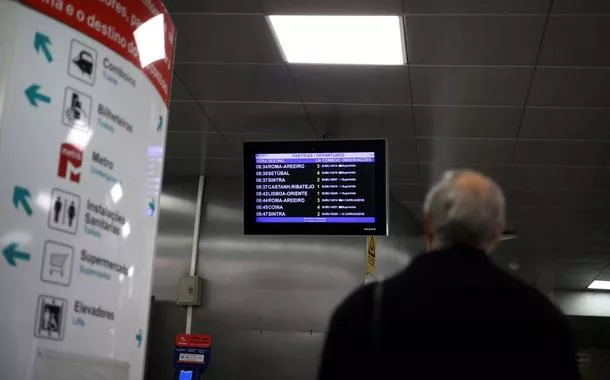 Homem olha para tela que marca partidas de trens na estação de Entrecampos, em Lisboa, em meio a greve geral no país
