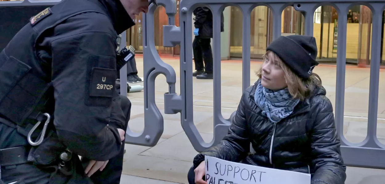 Greta Thunberg sentada em Londres, durante protesto em apoio a presos ligados ao Palestine Action, antes de ser detida pela polícia britânica