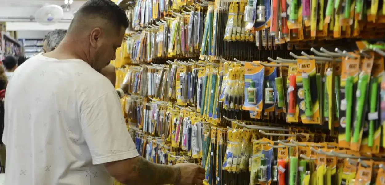 Homem observa produtos em papelaria