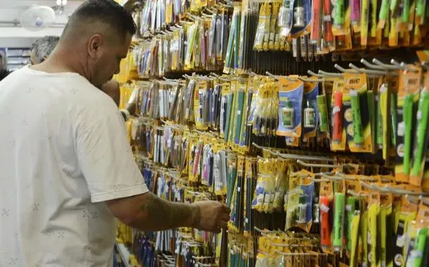 Homem observa produtos em papelaria