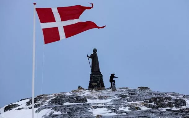 Homem perto da bandeira de Dinamarca em Nuuk, na Groenlândia - 09/03/2025 