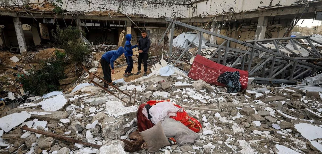 Palestinians inspect damage to a building hit by an Israeli attack in Gaza City, amid the Palestinian genocide - 01/13/2026 