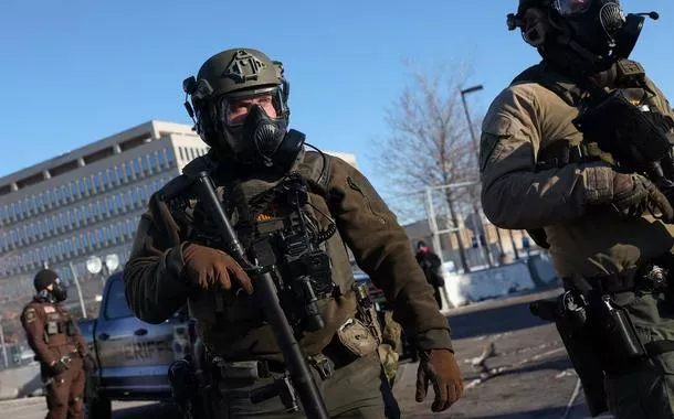 Membros das forças de segurança fazem guarda enquanto pessoas protestam em frente ao Edifício Federal Bishop Henry Whipple, em Minneapolis, Minnesota, Estados Unidos, em 30 de janeiro de 2026