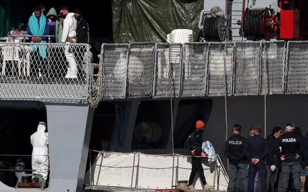 Migrantes se reúnem após desembarcarem do navio da Marinha italiana Cassiopea em Shengjin, Albânia, em 28 de janeiro de 2025