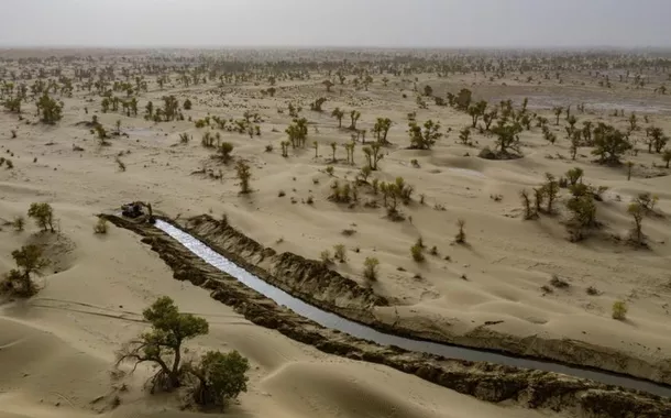 Foto aérea tirada por drone em 19 de setembro de 2025 mostra canal ecológico artificialmente escavado para desvio de enchentes e reabastecimento de água no Deserto de Taklimakan, no Condado de Yuli, Prefeitura Autônoma Mongol de Bayingolin, Região Autônoma Uigur de Xinjiang, noroeste da China. 