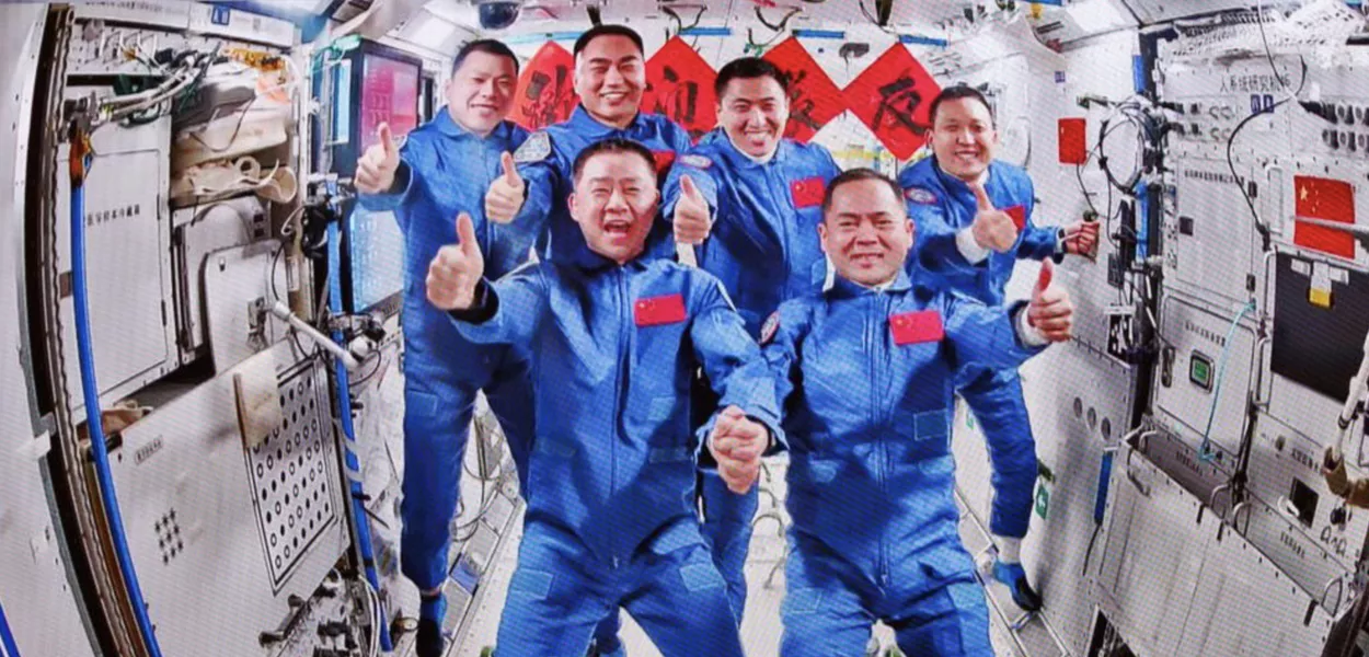 Esta imagem, capturada no Centro de Controle Aeroespacial de Pequim em 1º de novembro de 2025, mostra uma foto de grupo da tripulação das naves espaciais Shenzhou-20 e Shenzhou-21, na estação espacial da China. 
