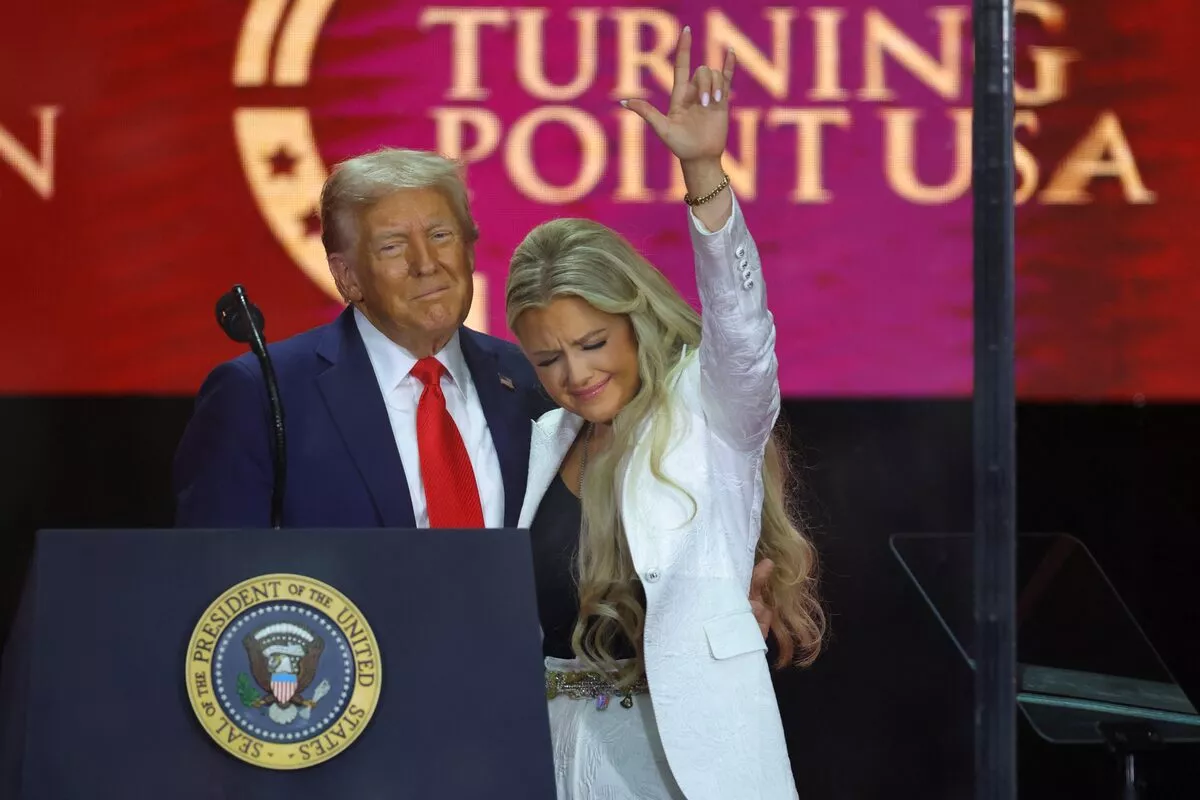 Donald Trump abraça Erika Kirk enquanto ela faz um gesto, durante o serviço memorial de seu marido, o comentarista conservador Charlie Kirk, em 21 de setembro de 2025