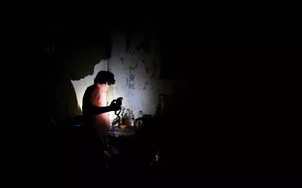Homem usa uma lanterna durante um apagão causado pelo colapso da rede elétrica nacional de Cuba, em Havana
REUTERS/Norlys Perez