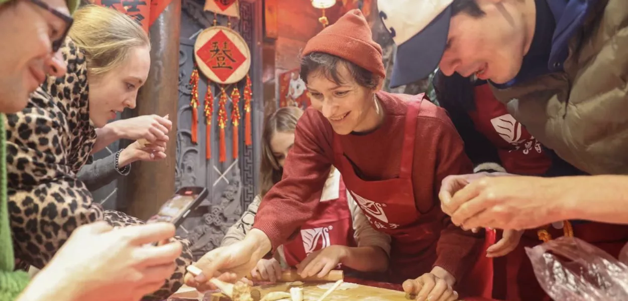 Turistas estrangeiros preparam bolinhos em um hotel em Sanmenxia, ​​na província de Henan, no centro da China