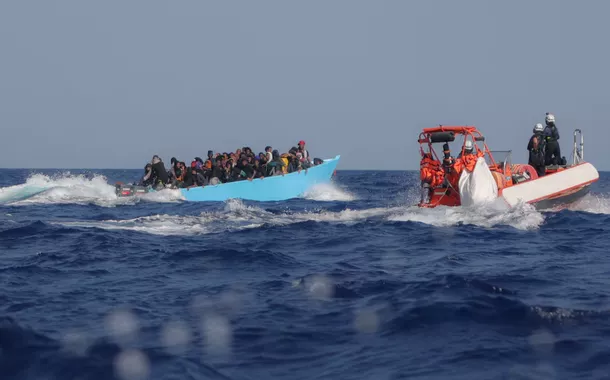Migrantes a bordo de uma embarcação superlotada são abordados pela tripulação do navio de busca e resgate Sea-Watch 5, operado pela ONG alemã Sea-Watch