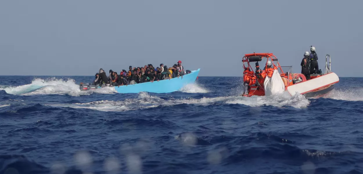 Migrantes a bordo de uma embarcação superlotada são abordados pela tripulação do navio de busca e resgate Sea-Watch 5, operado pela ONG alemã Sea-Watch