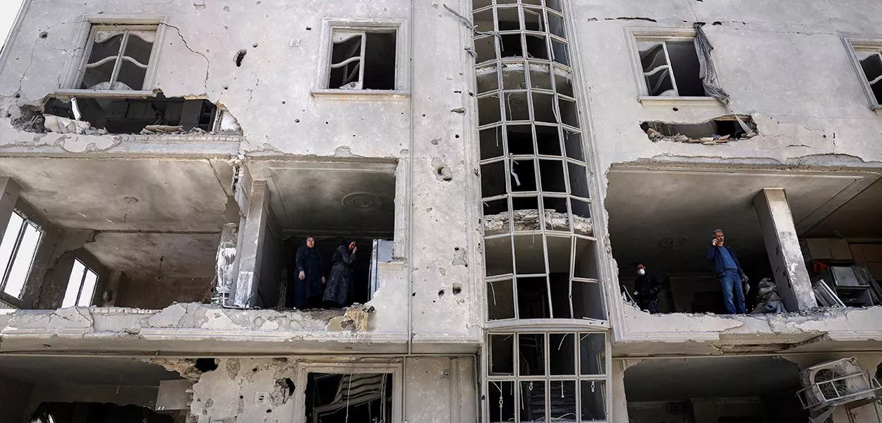 Pessoas inspecionam os danos em um prédio residencial após ser atingido por um ataque, em meio ao conflito entre EUA e Israel com o Irã, em Teerã30/03/2026Majid Asgaripour/WANA (Agência de Notícias da Ásia Ocidental) via REUTERS