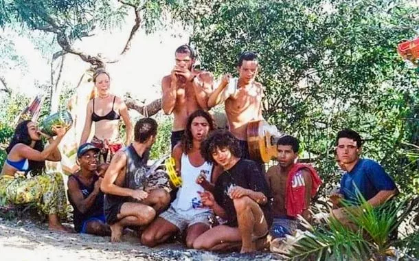 Lelê  tocando pandeiro amarelo tendo ao seu lado, de camiseta preta, o punkito.