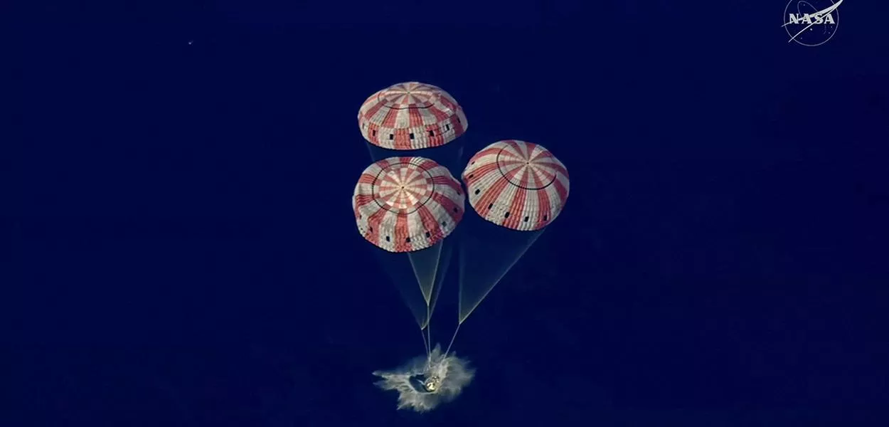 Cápsula da tripulação da Artemis 2 desce no Oceano Pacífico nesta captura de tela de vídeo de transmissão 