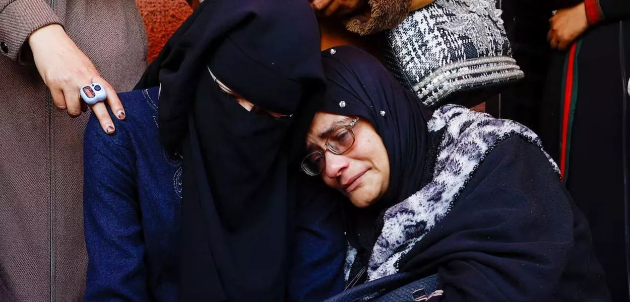 Enlutados reagem durante o funeral de palestinos mortos em um ataque israelense, segundo equipes médicas, no Hospital dos Mártires de Al-Aqsa, em Deir al-Balah, no centro da Faixa de Gaza, em 13 de abril de 2026