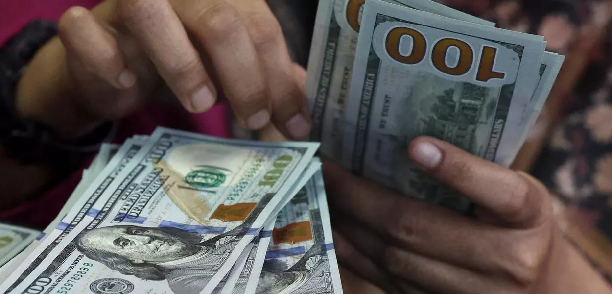 Pessoa conta notas de dólar em uma casa de câmbio em Jacarta, Indonésia, em 9 de abril de 2025.
