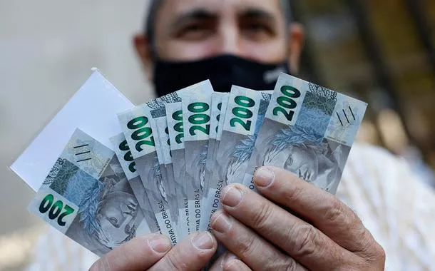 Um homem segura notas de 200 reais em Brasília