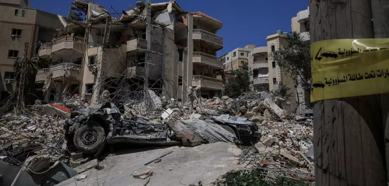 Um prédio danificado, escombros e um veículo destruído após ataques israelenses, nas proximidades do Hospital Hiram em Tiro, no sul do Líbano, 16 de abril de 2026