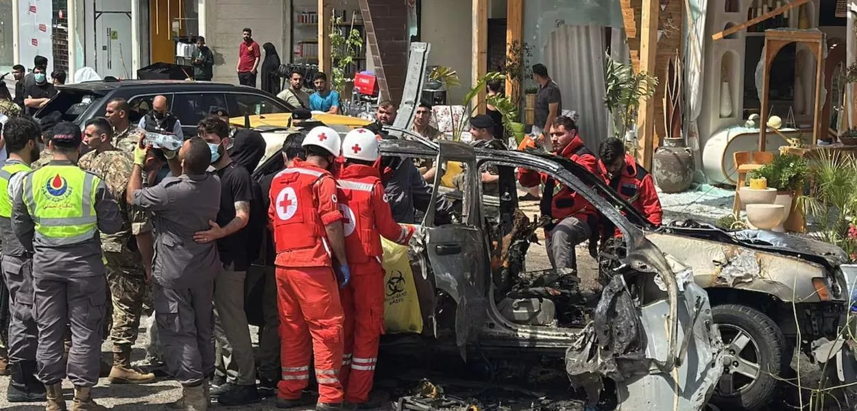 Socorristas inspecionam um carro atingido em um ataque israelense na área de Jiyeh, ao sul de Beirute, Líbano, em 13 de maio de 2026
