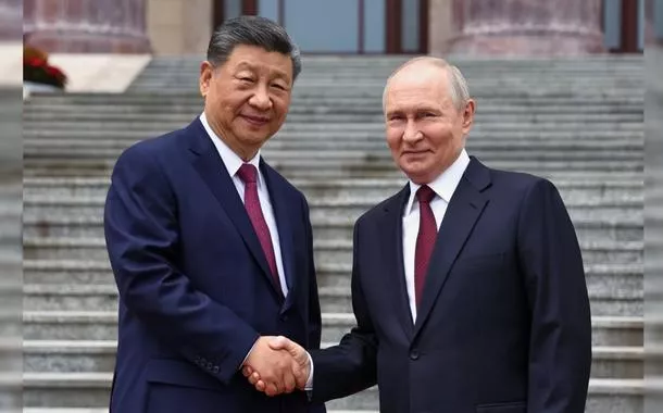 Pesidente russo Vladimir Putin (à direita) e o presidente chinês Xi Jinping apertam as mãos durante uma cerimônia de boas-vindas no Grande Salão do Povo, em Pequim, China, na quarta-feira, 20 de maio de 2026.

