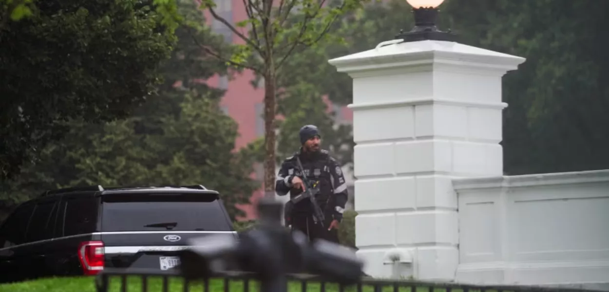 Agente do Serviço Secreto dos EUA permanece de guarda, segurando sua arma, após disparos terem sido ouvidos perto da Casa Branca