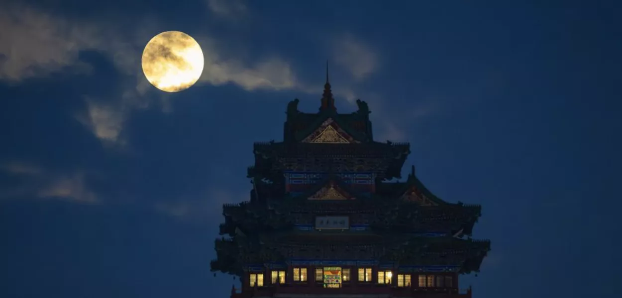 Uma lua cheia é vista acima da Torre Yuejiang, em Nanjing, na província de Jiangsu, no leste da China.