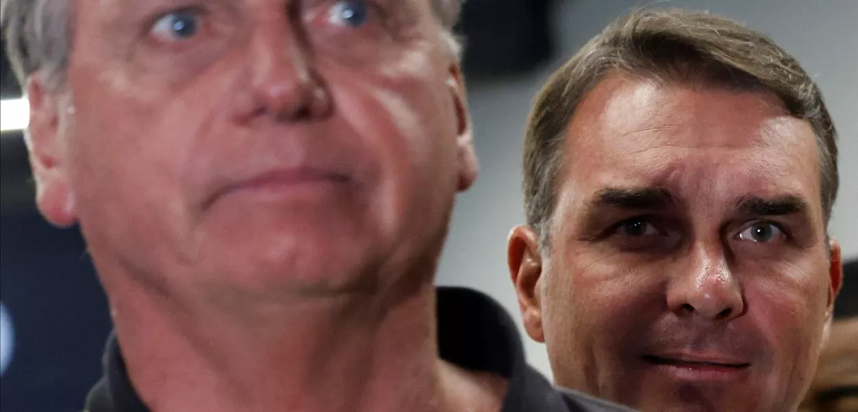 O senador Flávio Bolsonaro observa o pai, o ex-presidente Jair Bolsonaro, no Aeroporto Internacional de Brasília - 25/11/2024